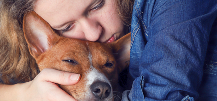 Person sitting comfortably at home with an emotional support dog providing companionship, representing the mental health benefits of a clinical support animal and ESA letter for housing