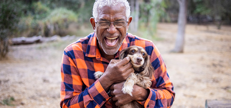 A happy tenant holding a legal ESA letter for housing while sitting with their emotional support dog.